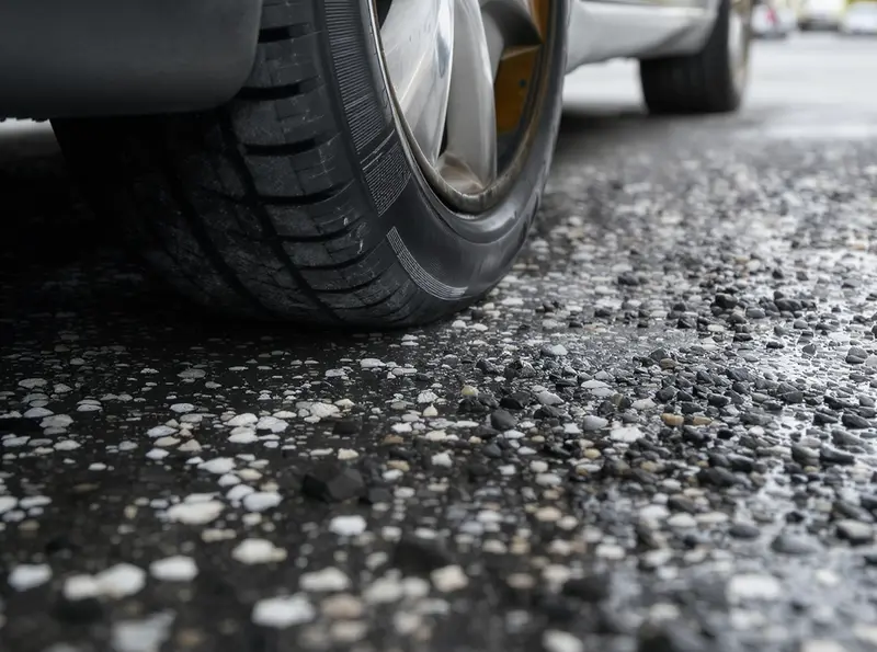 Como comprar um pneu mais durável para o seu carro: especialista explica Pneu de carro bem calibrado em asfalto, com foco nos detalhes da borracha e aderência. Simboliza manutenção automotiva.