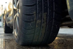 Close-up detalhado de um pneu e sistema de freio ABS de um carro, realçando a tecnologia de segurança.