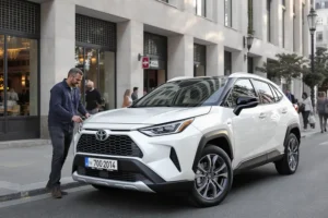 Toyota Corolla Cross 2025 branco estacionado em rua europeia, com pessoa se aproximando, detalhando design exclusivo e tecnologia.
