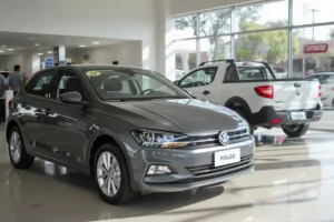 Dois carros, um Volkswagen Polo cinza e um Fiat Strada branco, dentro de um showroom.