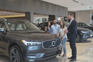 Família sorridente com vendedor em concessionária de luxo, olhando para um SUV de alto padrão.
